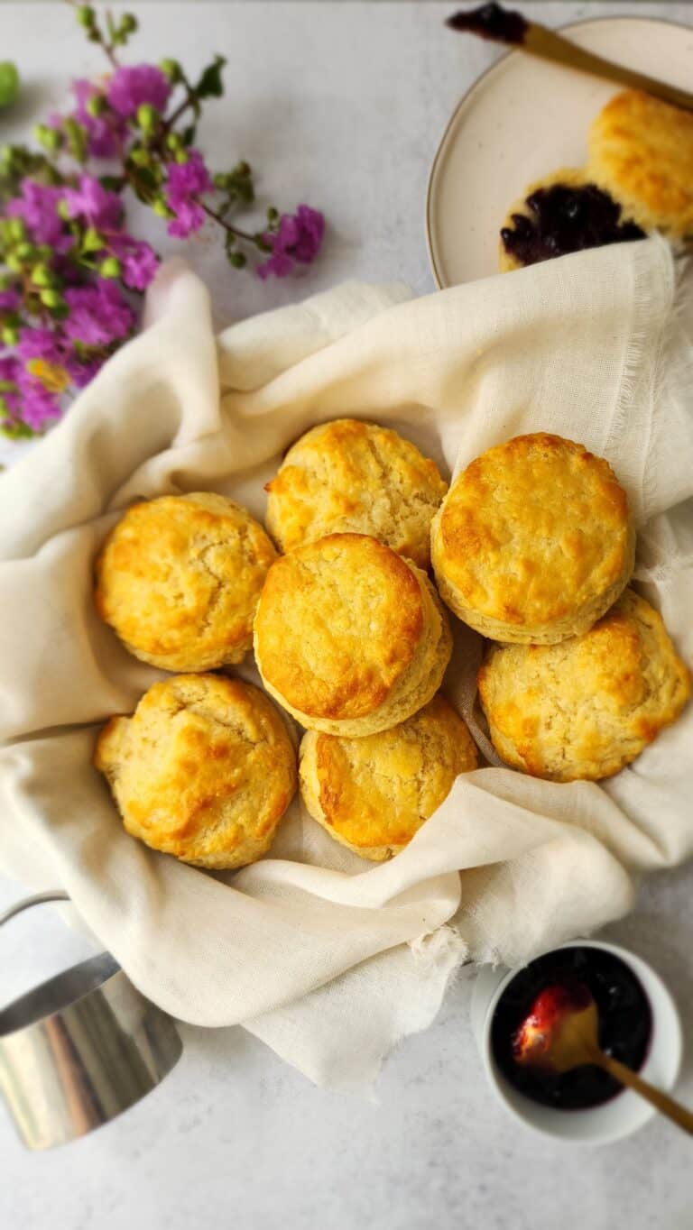 Buttermilk Biscuits in a biscuit with one biscuit cut open and with blueberry jam