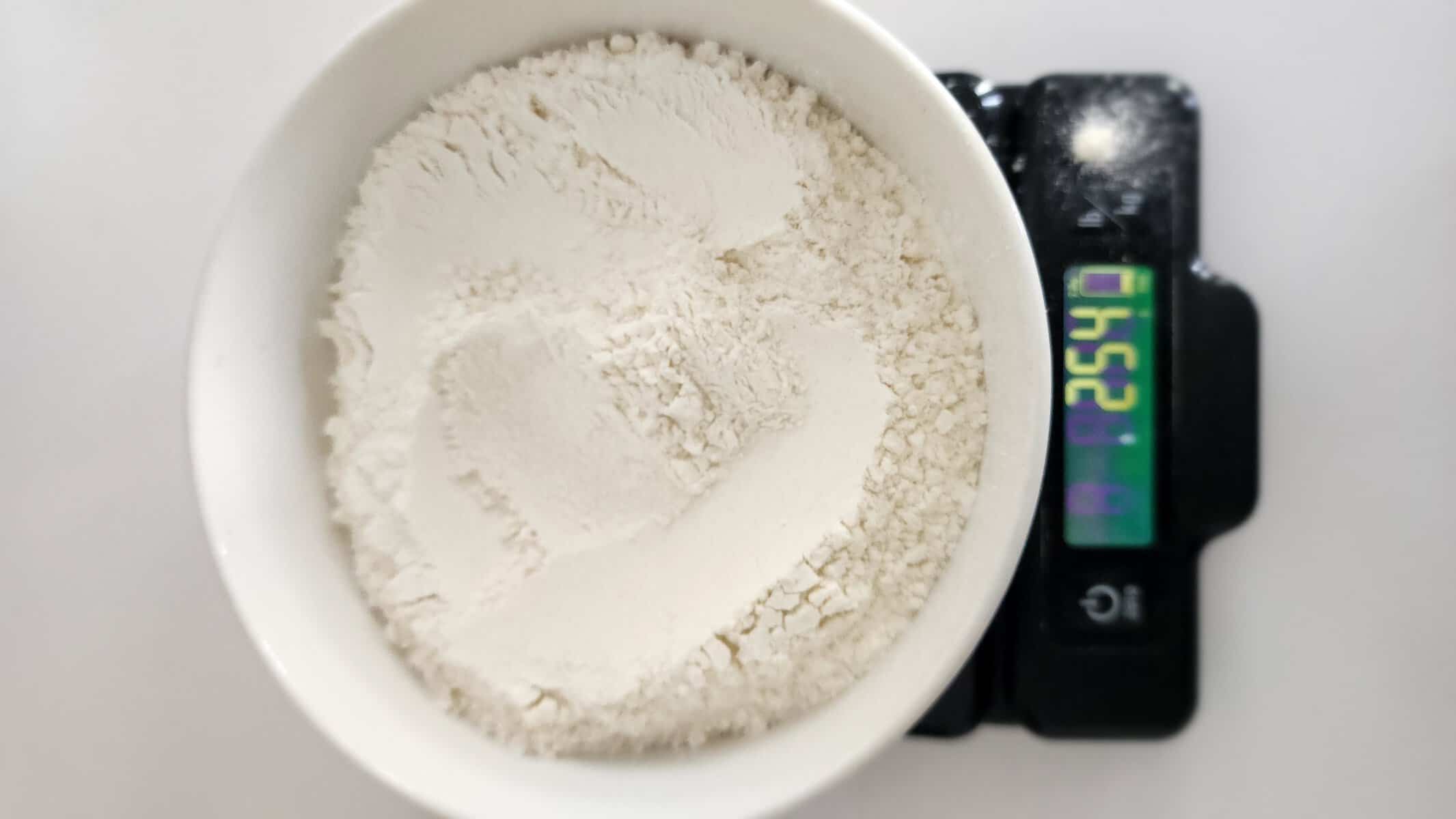 weighing flour on a scale for accuracy and precision