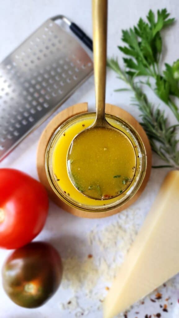 'Italian' Salad Dressing - a spoonful of the dressing out of a mason jar on display