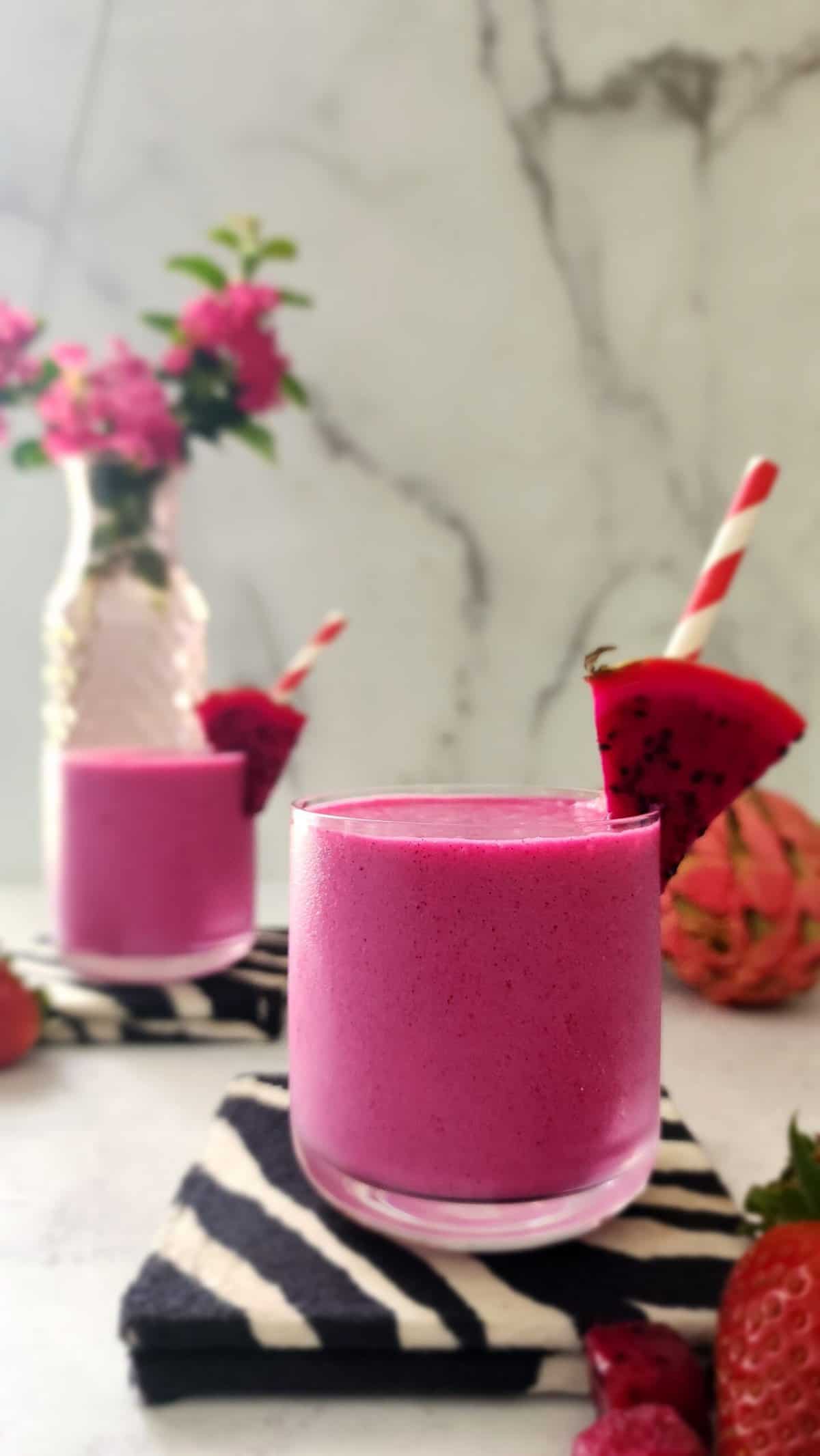 Dragon Fruit Smoothie head on with a slice of red dragon fruit and straw