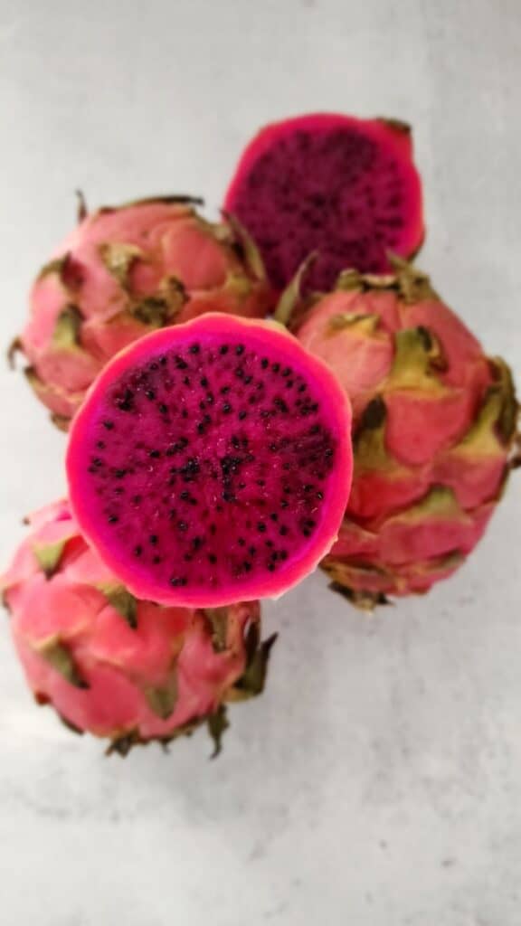 Cut open red dragon fruit red flesh