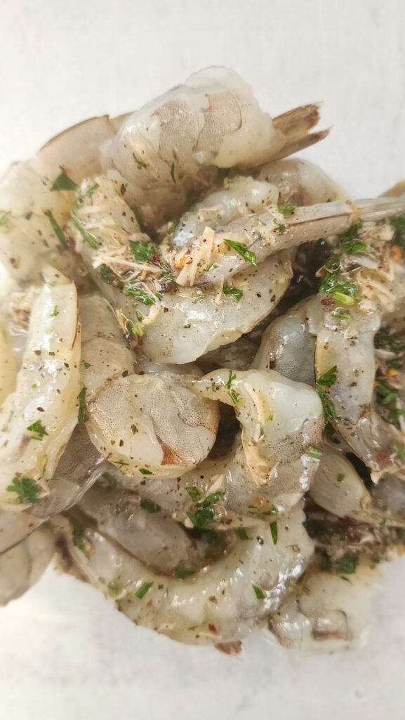 bowl of jumbo shrimp marinating for grilled shrimp