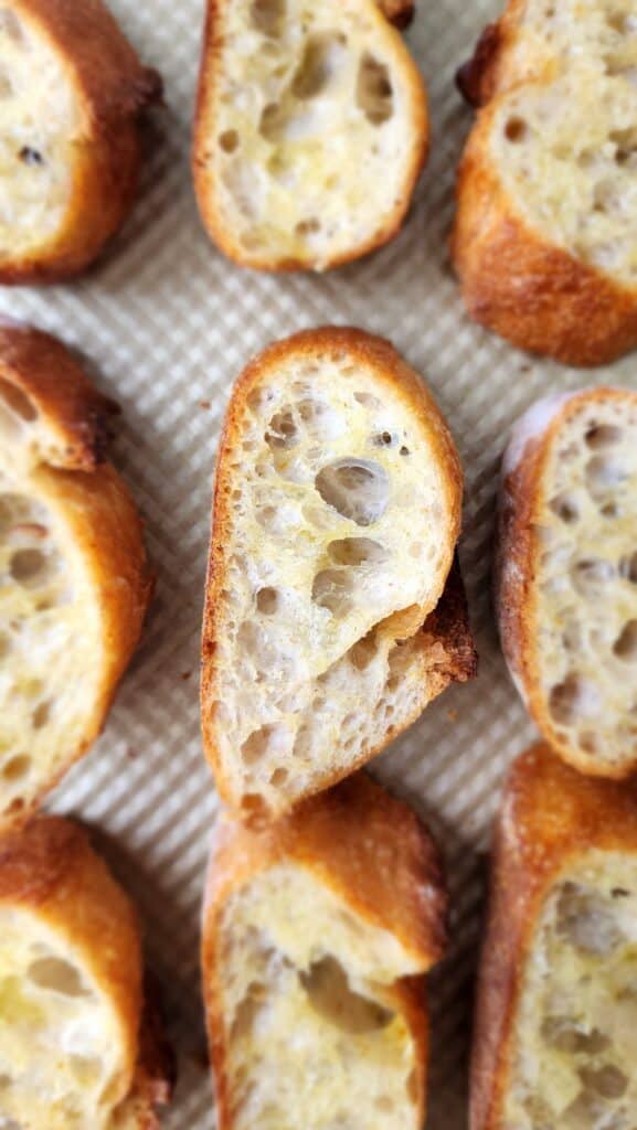 Italian Baguette in cut slices on a baking sheet