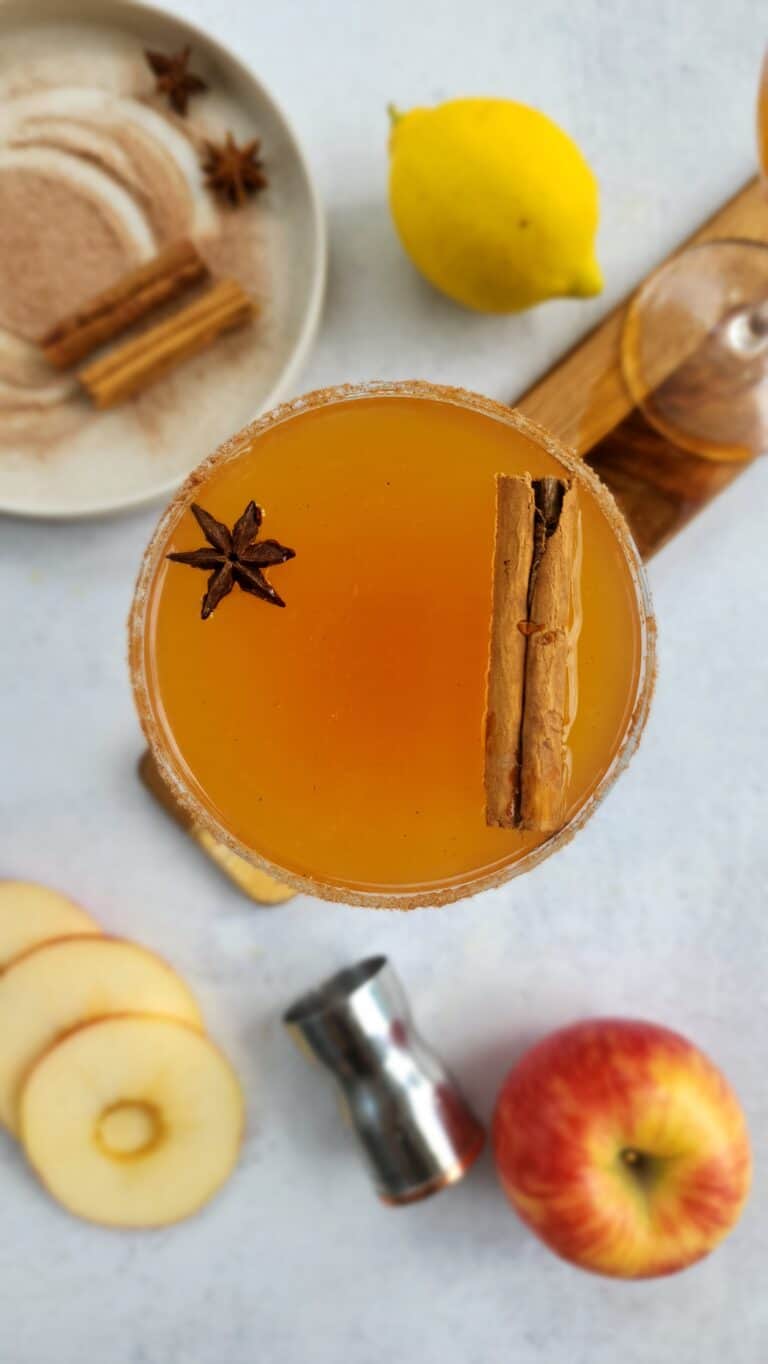 top shot of an apple cider margarita with apple slices and cinnamon sugar plate