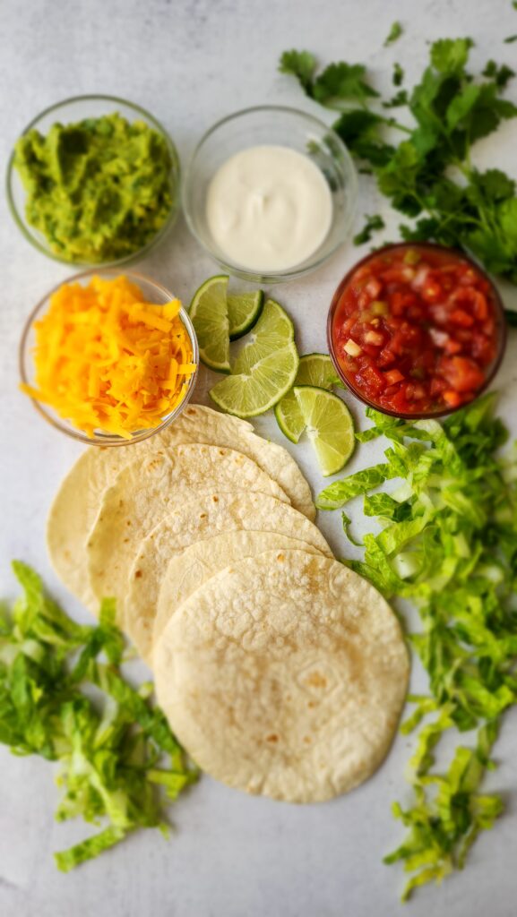 Taco toppings - shredded cheese, lettuce, salsa, guacamole, greek yogurt