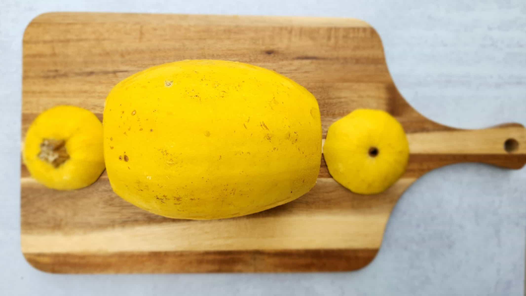 Ends cut off of a spaghetti squash on a wood cutting board