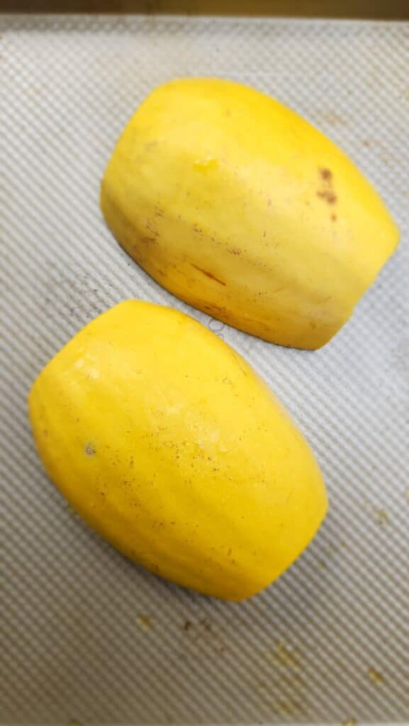 Spaghetti Squash face down ready to roast on a sheet pan