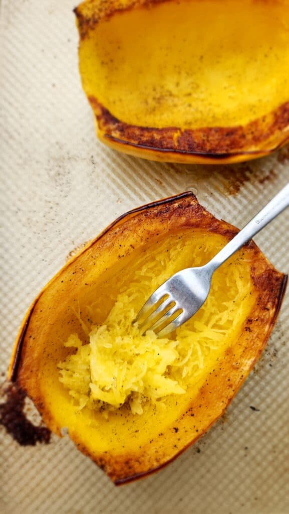 Roasted Spaghetti Squash on a sheet pan, fork scraping