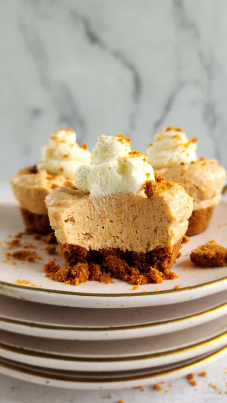 plate of mini no-bake sweet potato cheesecakes with a bite taken out of the front cheesecake