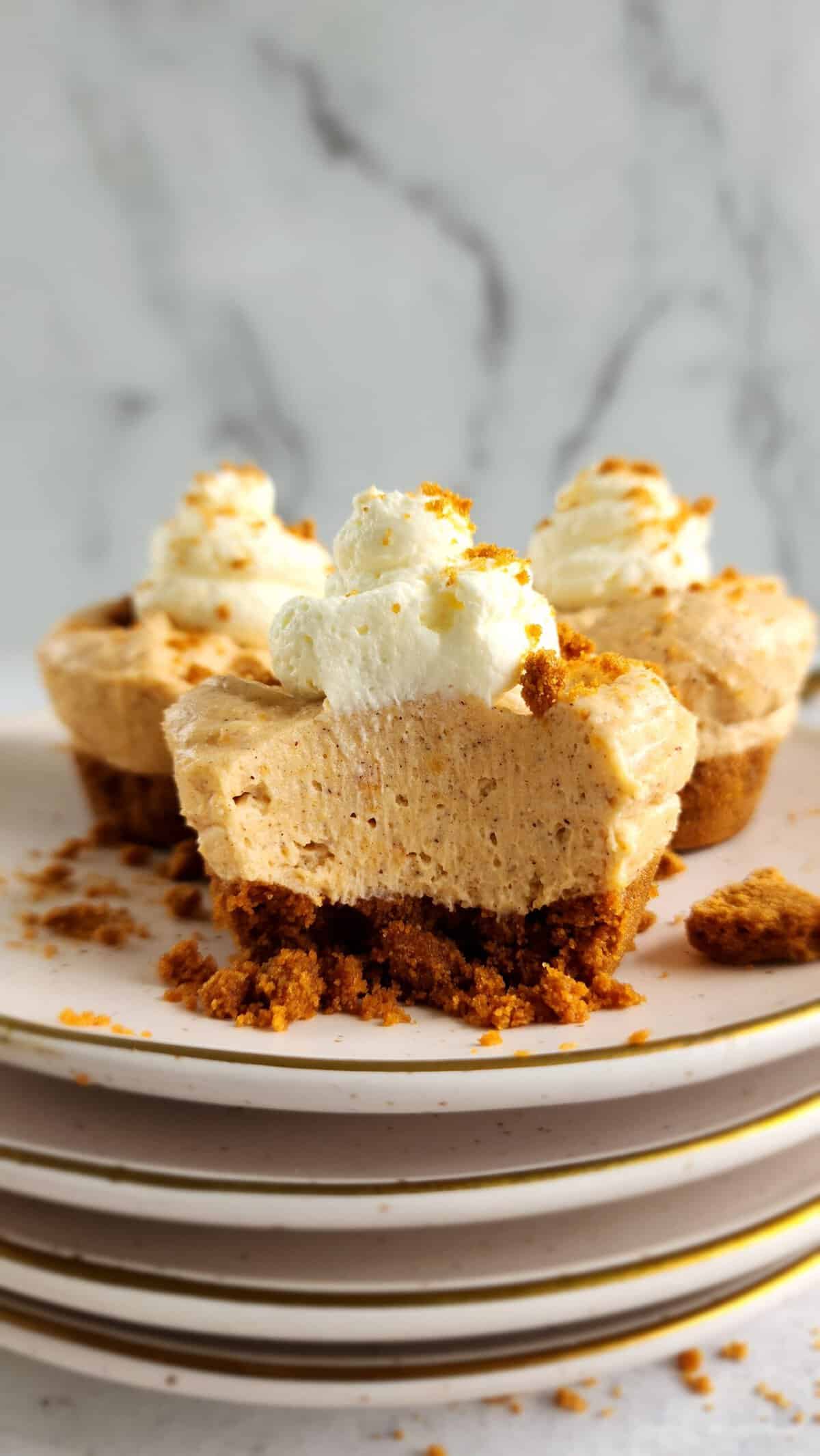 plate of mini no-bake sweet potato cheesecakes with a bite taken out of the front cheesecake